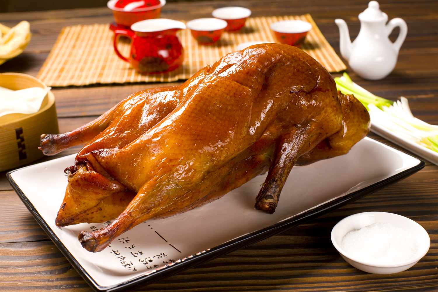 A chef carving Peking Duck tableside in a traditional restaurant. 