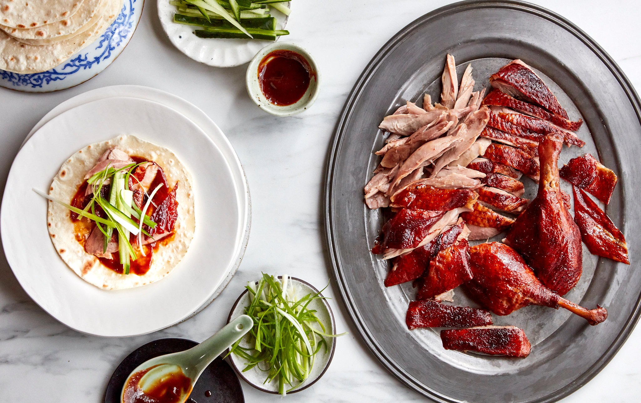 Peking Duck wraps with pancakes, hoisin sauce, and vegetables. 